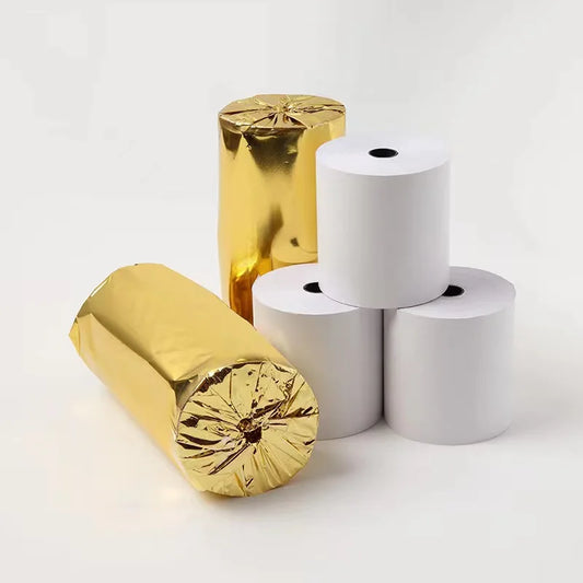 Two gold covered thermal rolls of paper and two white rolls of paper on a light gray background